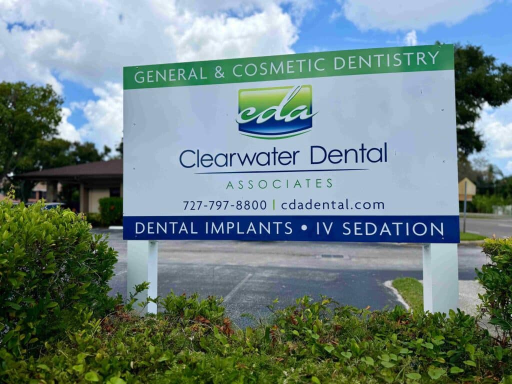 Clearwater Dental Associates outdoor signboard highlighting dental implants and IV sedation with contact 727-797-8800 and cdadental.com.